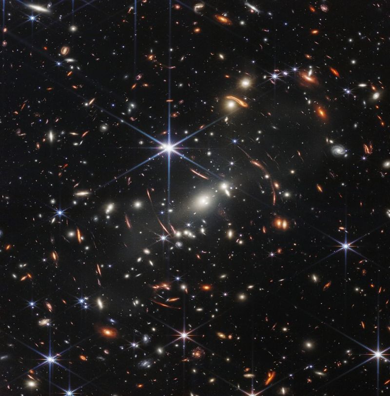 False color image of galaxy cluster SMACS 0723 from JWST’s Near-Infrared Camera (NIRCam). The combined mass of this galaxy cluster acts as a gravitational lens, magnifying more distant galaxies, including some seen when the universe was less than a billion years old.
